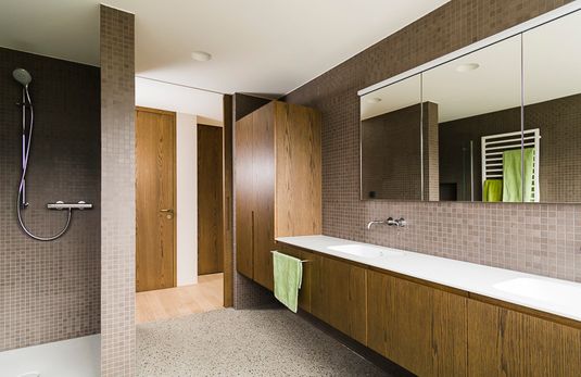 Badezimmer mit Maßmöbel und ebenerdiger Dusche